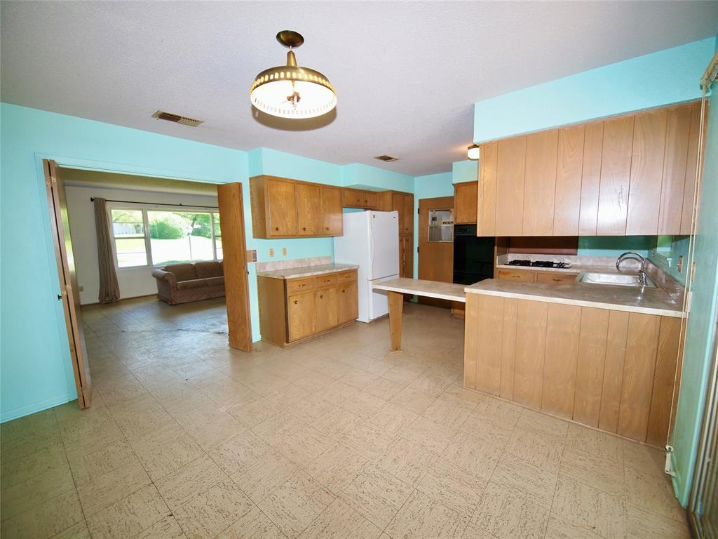 1441 Brazos Street Graham, TX 76450 - Photo 7 of 34 a room with furniture and a kitchen