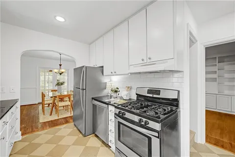 a kitchen with a stove a refrigerator and furniture