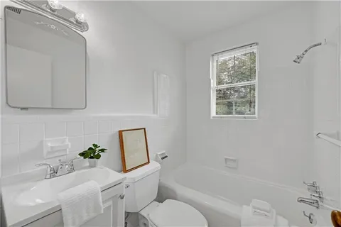 an empty room with wooden floor ceiling fan and windows