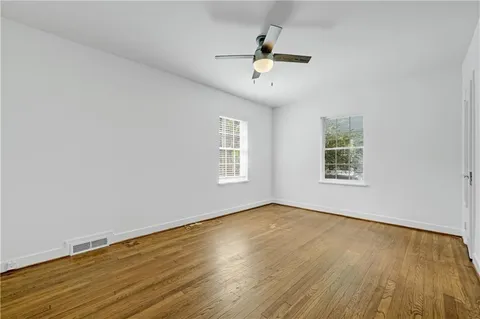 a view of a room with wooden floor and a ceiling fan