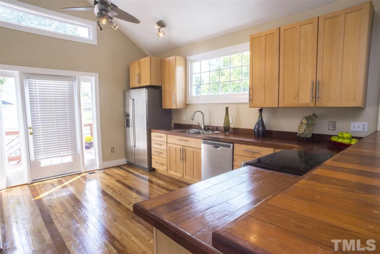 702 East Edenton Street Raleigh, NC 27601 - Photo 5 of 19 a kitchen with granite countertop wooden floors a sink stainless steel appliances and window