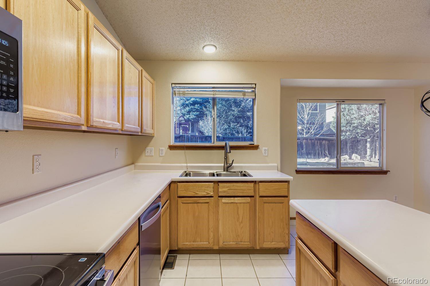 10505 Hyacinth Place Highlands Ranch, CO 80129 - Photo 11 of 40 a view of a kitchen with a sink cabinets and wooden floor