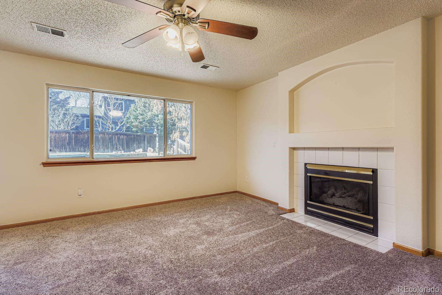 10505 Hyacinth Place Highlands Ranch, CO 80129 - Photo 18 of 40 an empty room with chandelier fan and windows