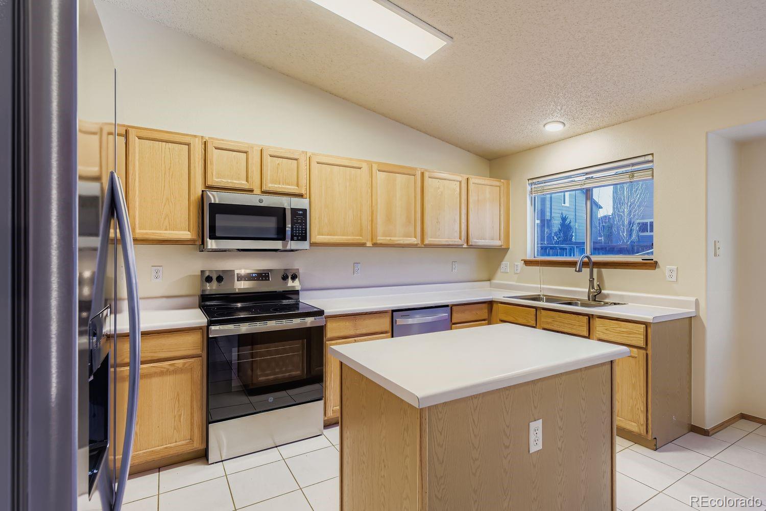 10505 Hyacinth Place Highlands Ranch, CO 80129 - Photo 8 of 40 a kitchen with a sink a stove top oven a counter top space and cabinets