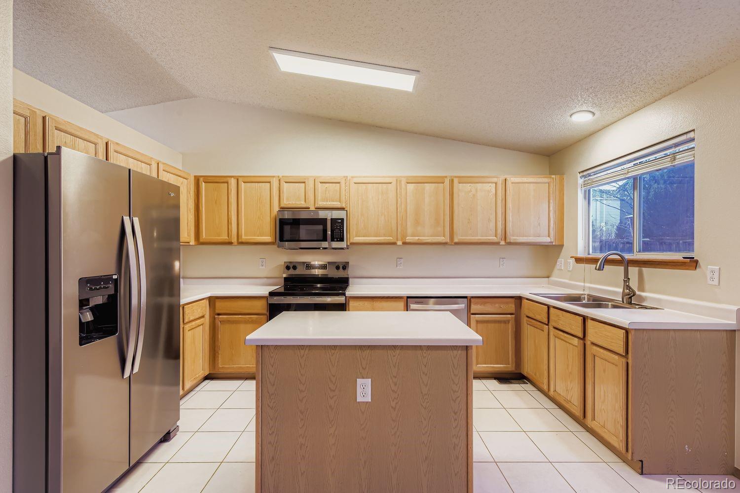 10505 Hyacinth Place Highlands Ranch, CO 80129 - Photo 10 of 40 a kitchen with stainless steel appliances a refrigerator stove microwave and sink