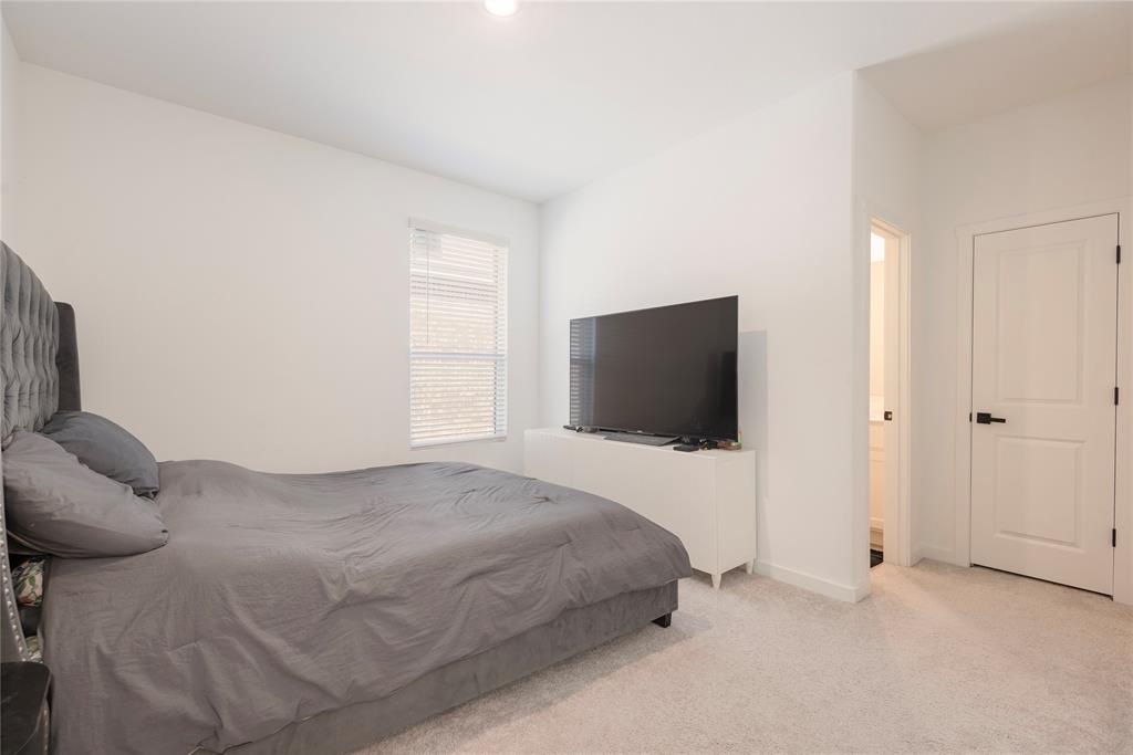 512 Capstone Court Princeton, TX 75407 - Photo 16 of 32 a bedroom with a bed and a flat screen tv