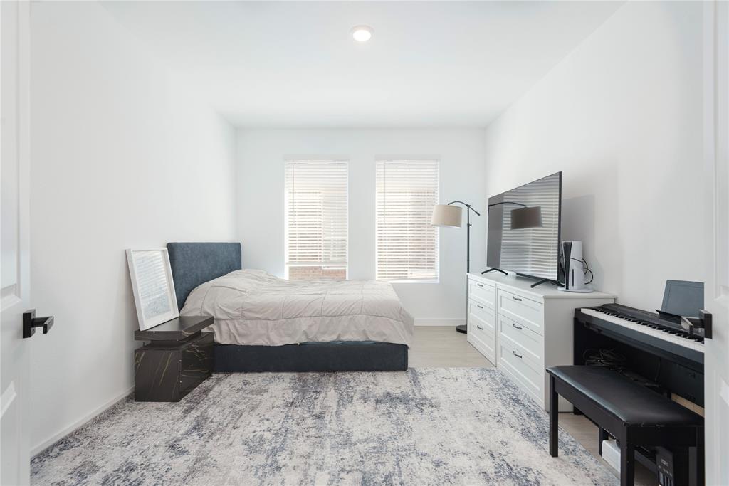 512 Capstone Court Princeton, TX 75407 - Photo 18 of 32 a bedroom with a bed and a flat screen tv