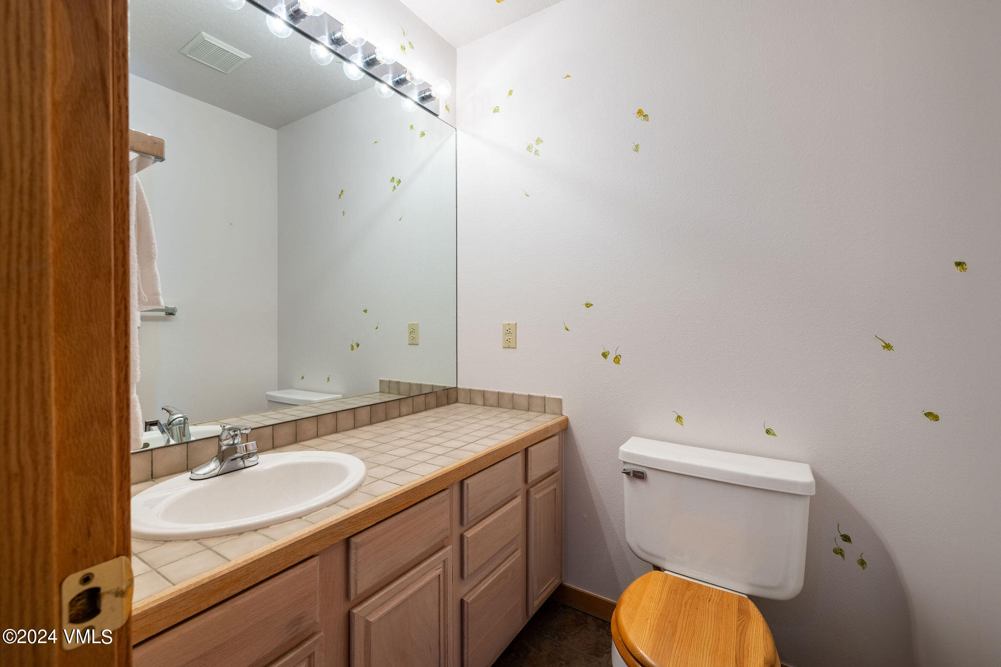 3891 Big Horn Road, Unit D Vail, CO 81657 - Photo 23 of 28 a bathroom with a granite countertop toilet sink and mirror
