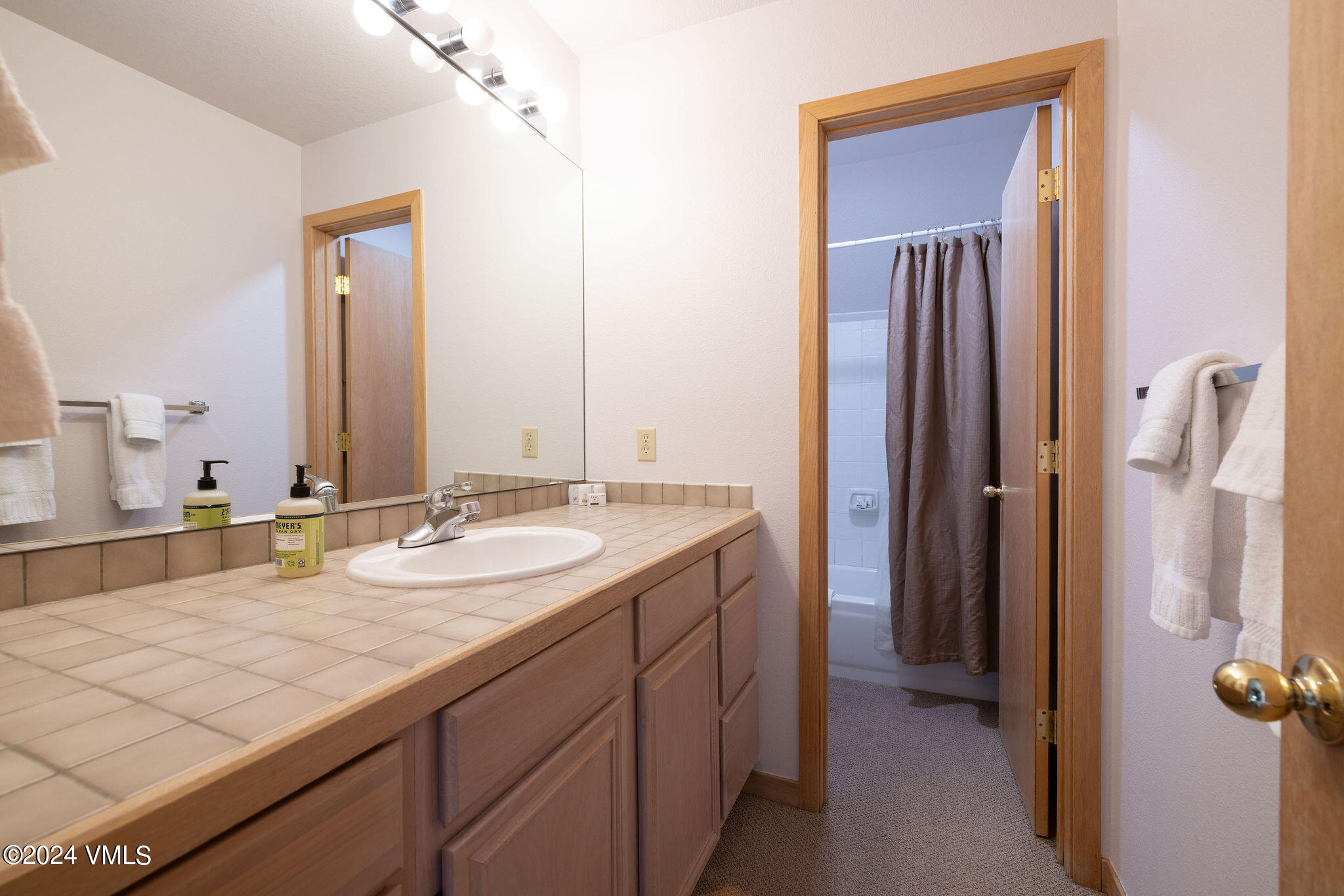 3891 Big Horn Road, Unit D Vail, CO 81657 - Photo 26 of 28 a bathroom with a granite countertop sink and a mirror