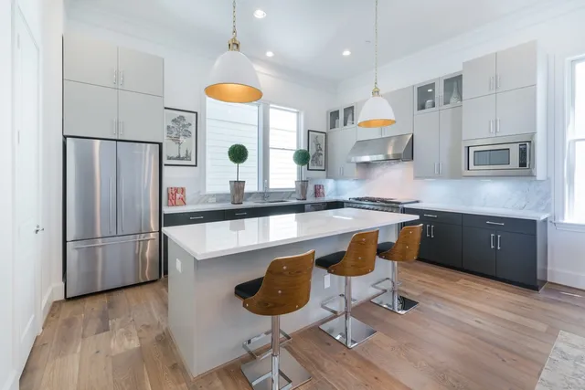 a kitchen with stainless steel appliances granite countertop a sink a stove a refrigerator and island