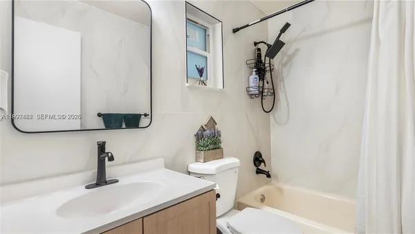 a bathroom with a sink vanity mirror and tub