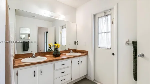 a bathroom with double sink and a mirror