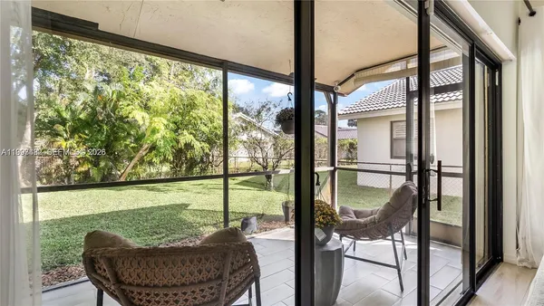 a balcony view with a glass top table and chairs