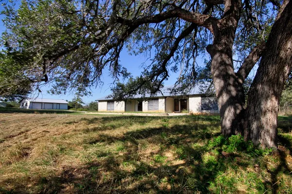 a view of a yard in front of a house with large trees
