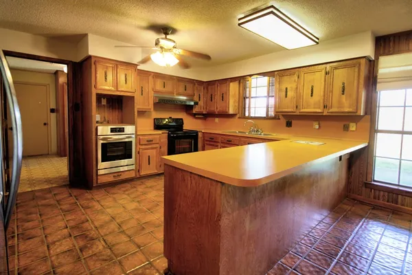 a kitchen with stainless steel appliances granite countertop a stove a sink dishwasher and a refrigerator