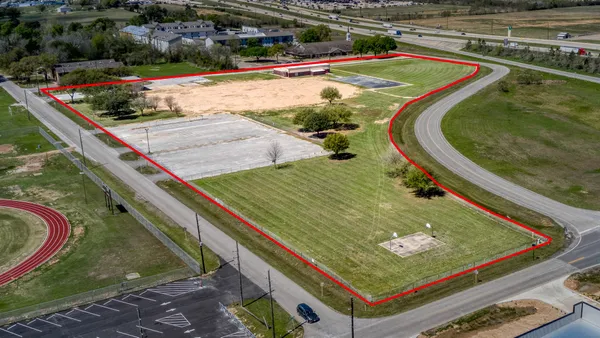 an aerial view of a pool and a yard