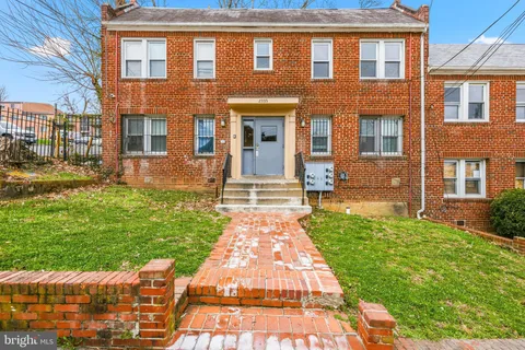 front view of a brick house with a yard