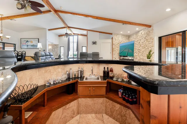 a large kitchen with stainless steel appliances granite countertop lots of counter top space and wooden floor