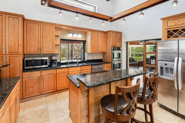 a bathroom with a granite countertop sink a mirror and a shower