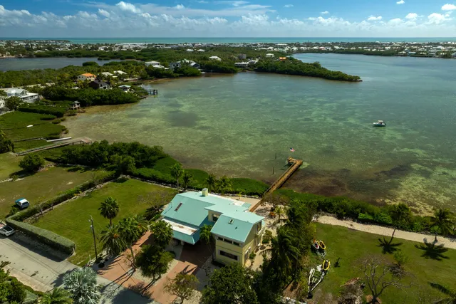 an aerial view of lake residential house with outdoor space and trees around