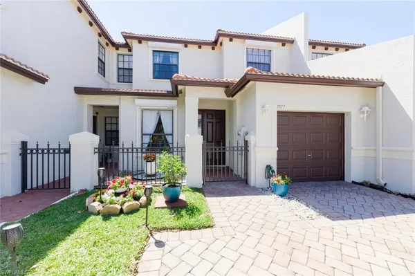 a front view of a house with garden and plants