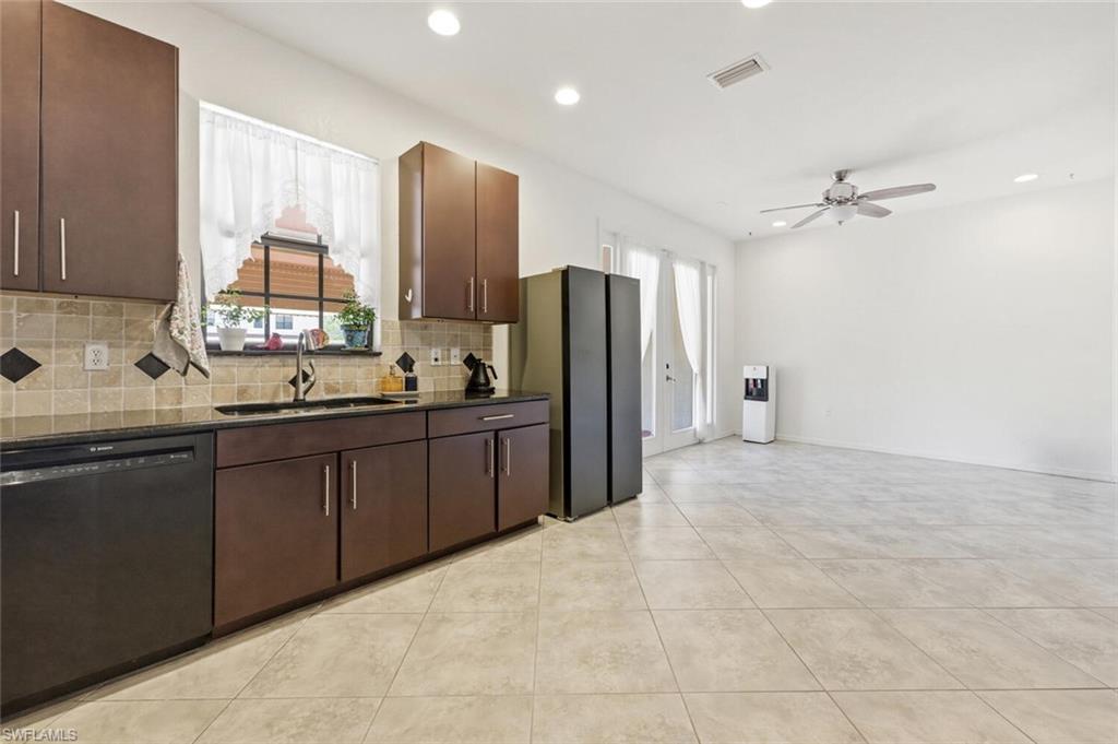 7577 Bristol Circle Naples, FL 34120 - Photo 12 of 41 a kitchen with stainless steel appliances a refrigerator sink and cabinets