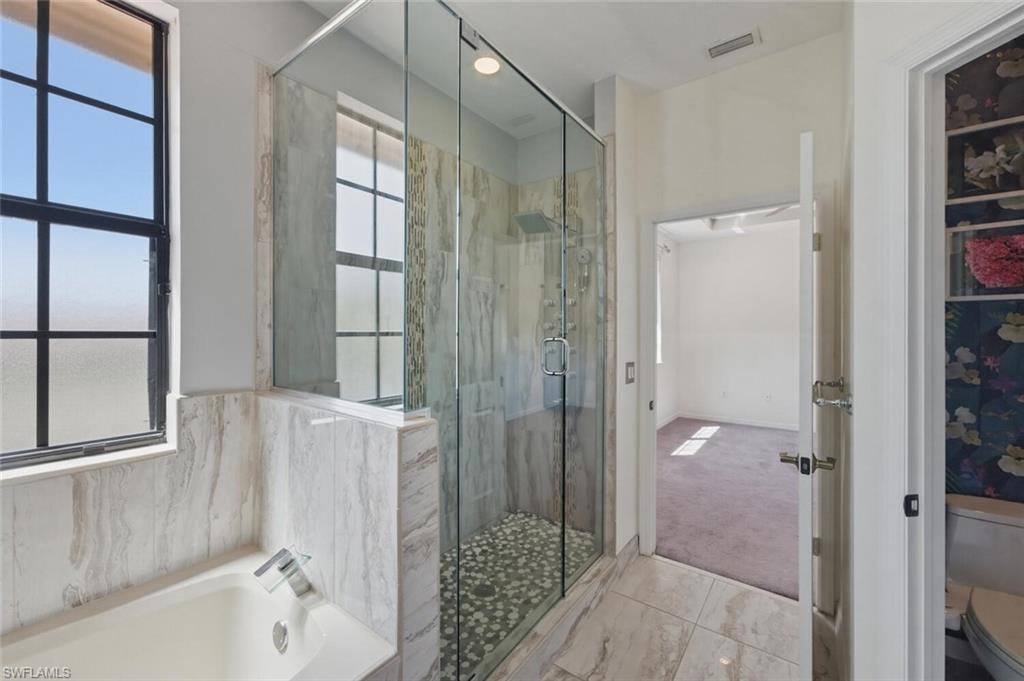 7577 Bristol Circle Naples, FL 34120 - Photo 20 of 41 a bathroom with a bathtub and a shower