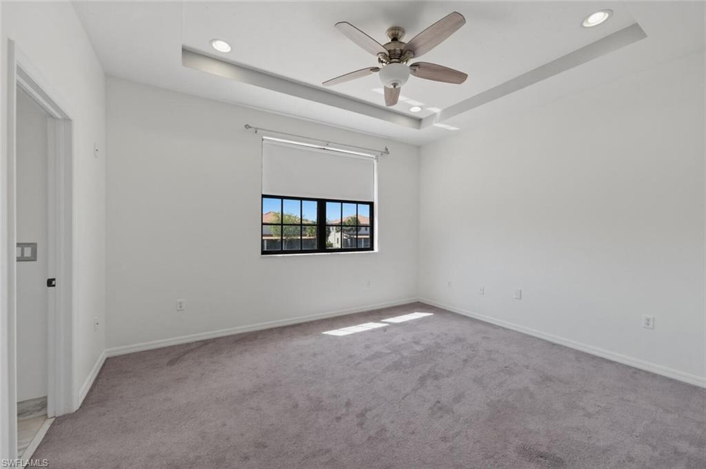 7577 Bristol Circle Naples, FL 34120 - Photo 24 of 41 en empty room with windows and ceiling fan