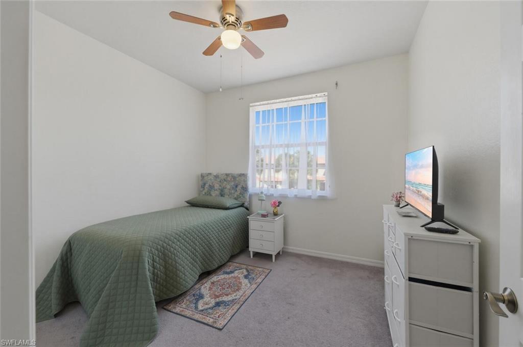 7577 Bristol Circle Naples, FL 34120 - Photo 26 of 41 a bedroom with a bed and a flat tv screen on the dresser