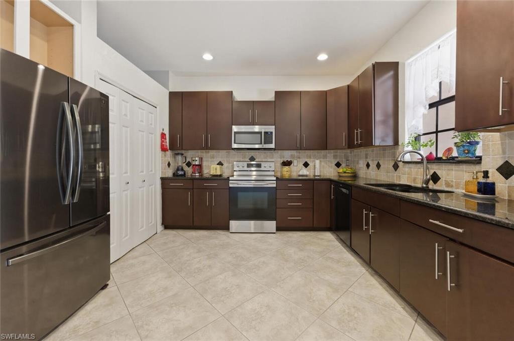 7577 Bristol Circle Naples, FL 34120 - Photo 3 of 41 a kitchen with stainless steel appliances granite countertop a refrigerator sink and cabinets