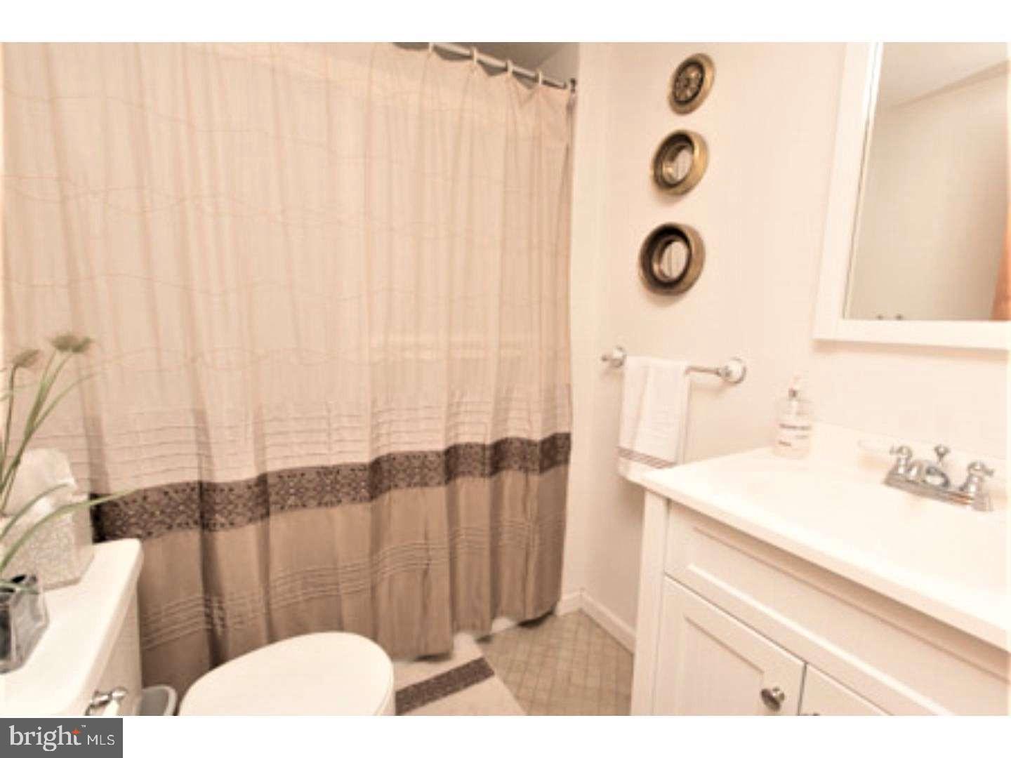 8 Rex Avenue, Unit 11 Philadelphia, PA 19118 - Photo 15 of 25 a bathroom with a sink and a mirror