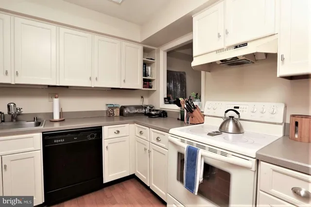 a kitchen with cabinets appliances a sink and a counter top