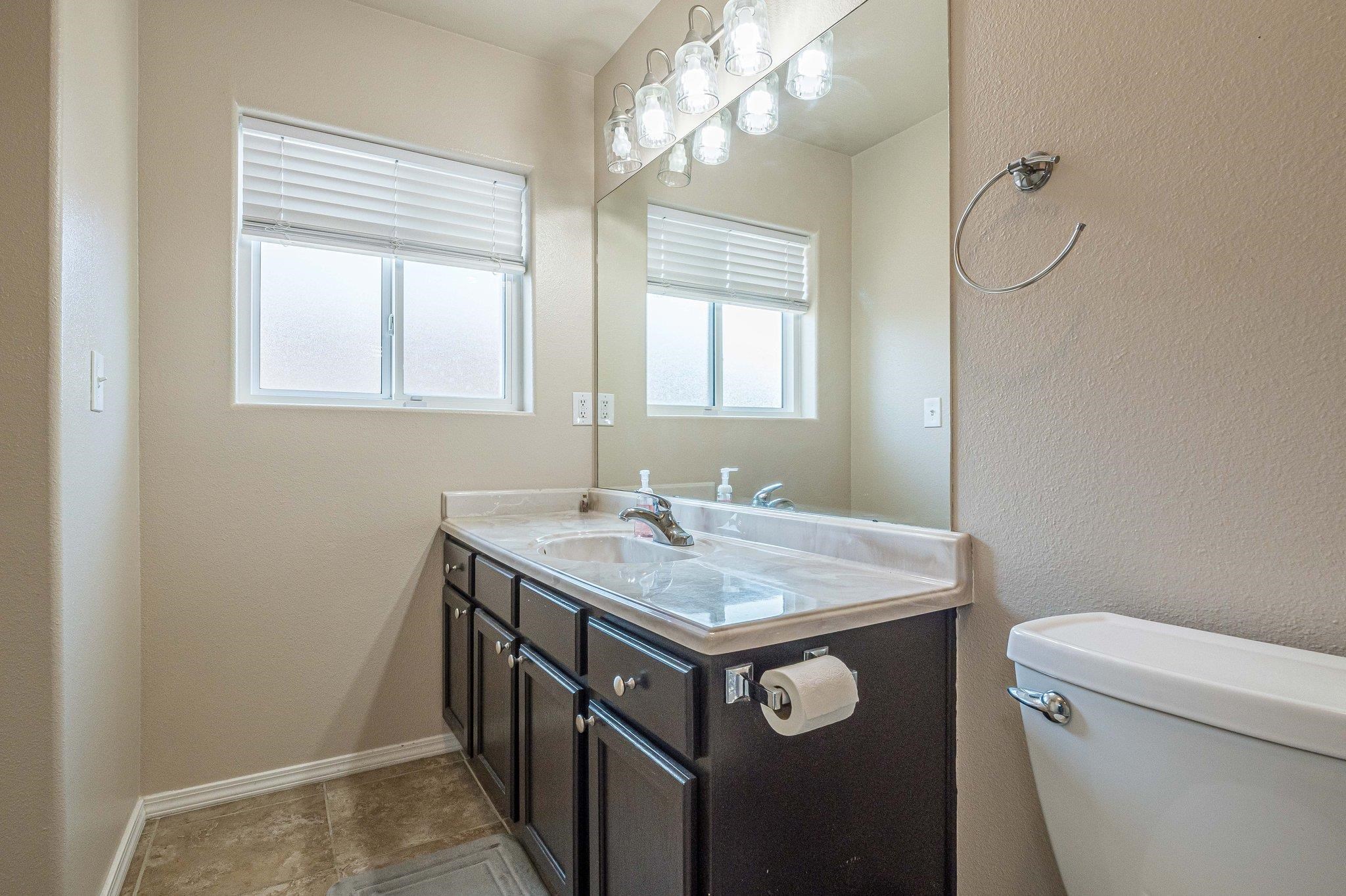 424 1/2 29 1/2 Road Grand Junction, CO 81504 - Photo 26 of 40 a bathroom with a granite countertop sink a toilet a mirror and a window