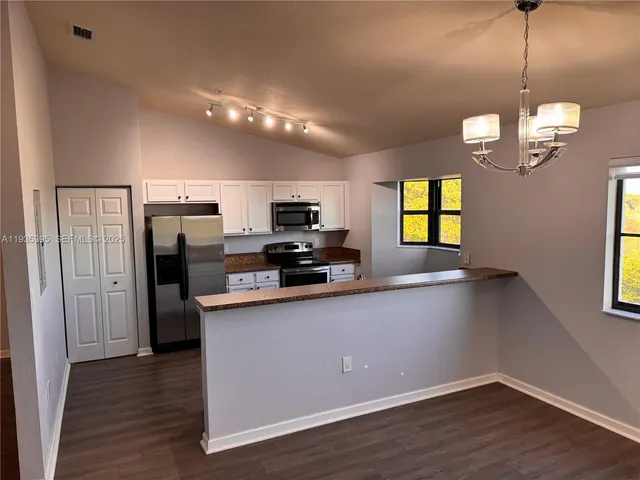 a kitchen with stainless steel appliances a refrigerator sink and microwave