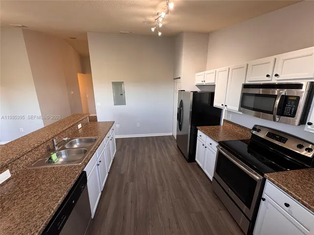 a kitchen with stainless steel appliances granite countertop a stove a sink and a refrigerator