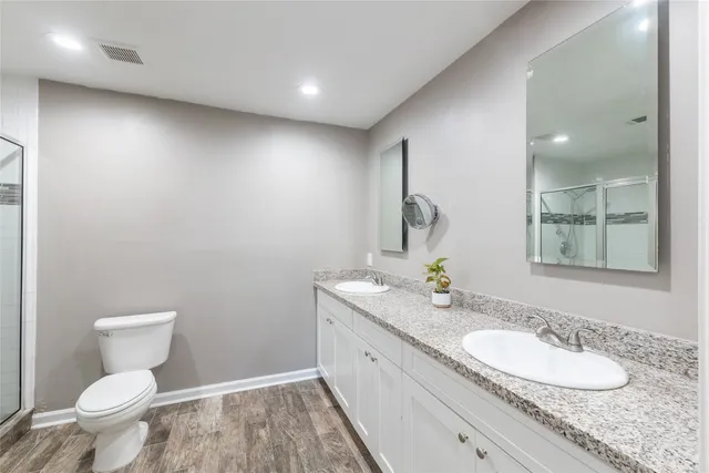 a bathroom with a granite countertop sink mirror vanity and toilet