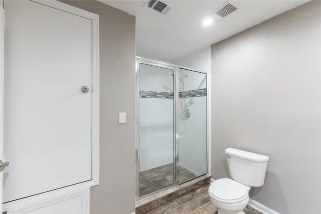 a bathroom with a toilet and a shower