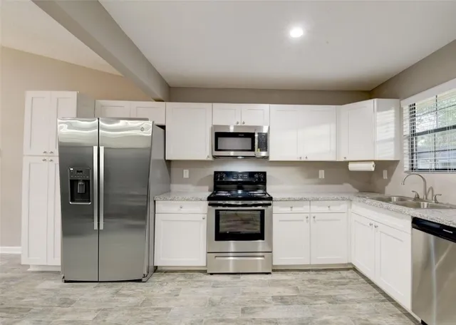a kitchen with a sink stainless steel appliances and cabinets