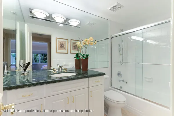 a bathroom with a granite countertop sink a toilet and shower