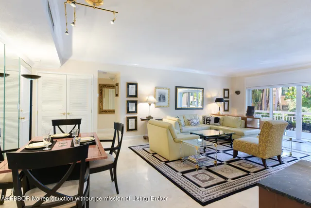 a living room with furniture large window and wooden floor