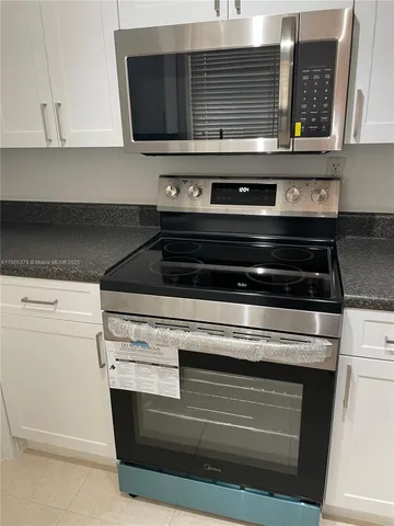 a stove top oven sitting inside of a kitchen