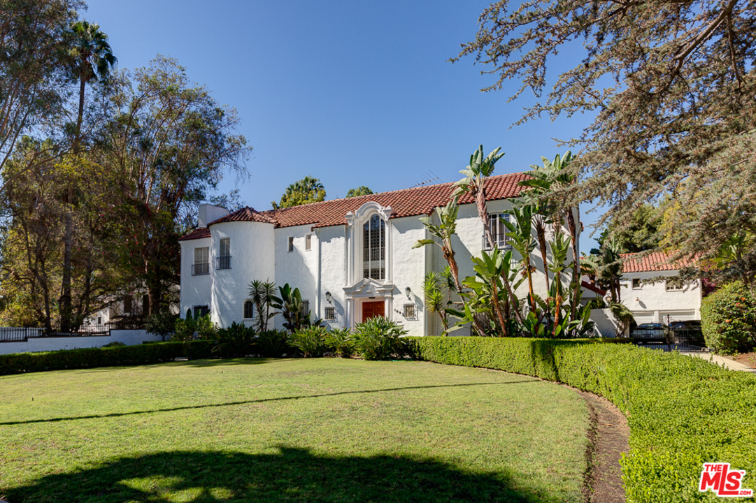 1003 Benedict Canyon Drive Beverly Hills, CA 90210 - Photo 2 of 35 a front view of a house with a yard