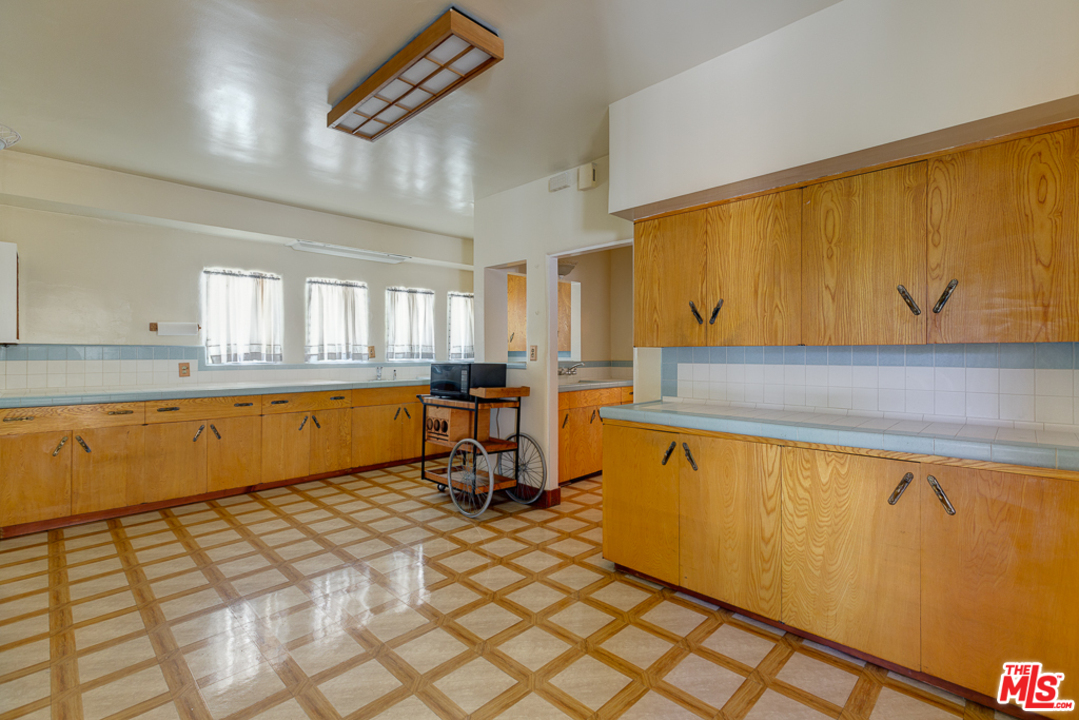 1003 Benedict Canyon Drive Beverly Hills, CA 90210 - Photo 11 of 35 a view of a kitchen with kitchen island a counter top space and a sink