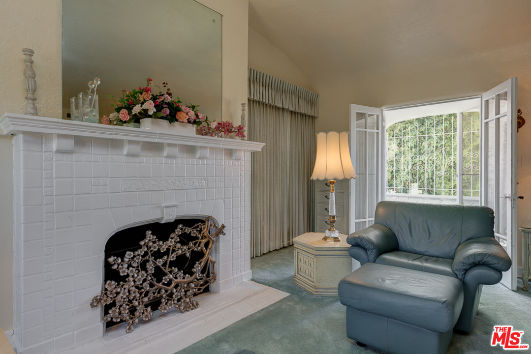 1003 Benedict Canyon Drive Beverly Hills, CA 90210 - Photo 18 of 35 a living room with furniture a fireplace and a window