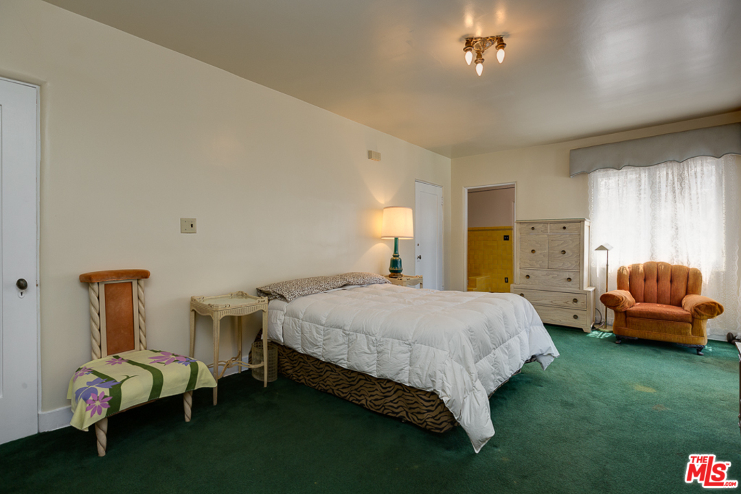1003 Benedict Canyon Drive Beverly Hills, CA 90210 - Photo 21 of 35 a spacious bedroom with a bed and a couch