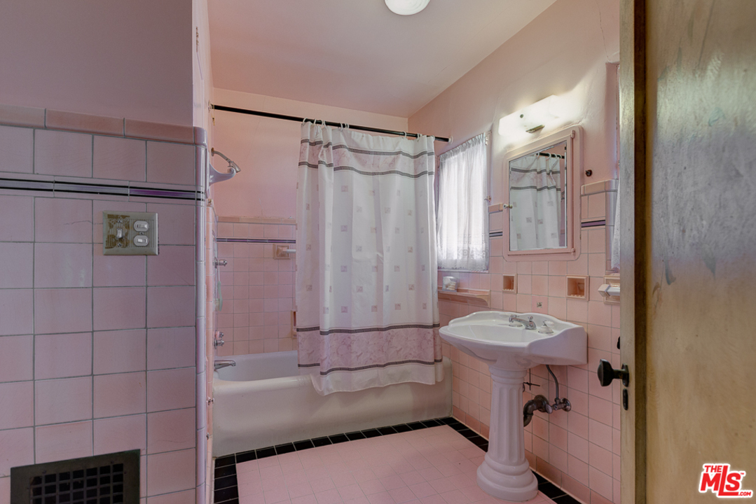 1003 Benedict Canyon Drive Beverly Hills, CA 90210 - Photo 22 of 35 a bathroom with a sink toilet tub and shower