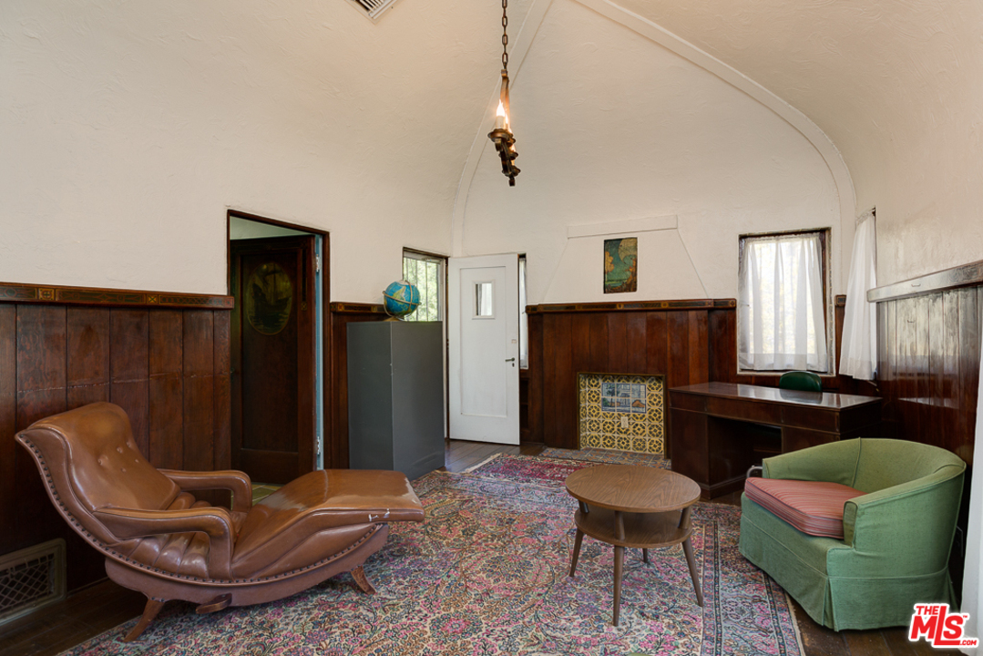 1003 Benedict Canyon Drive Beverly Hills, CA 90210 - Photo 24 of 35 a living room with furniture a flat screen tv and a fireplace