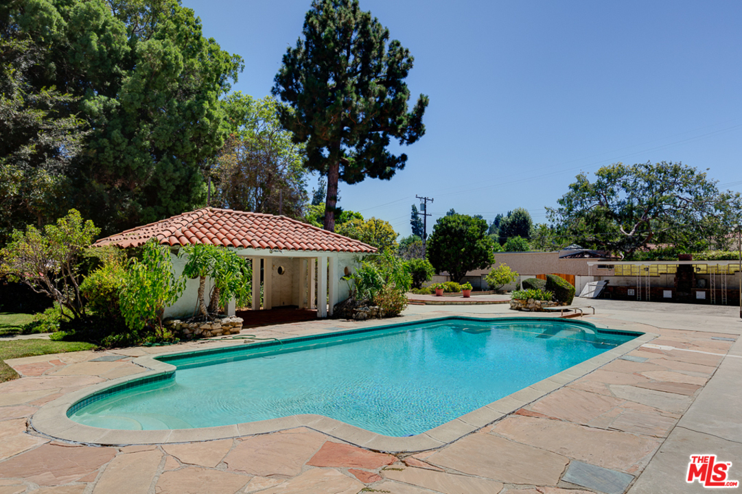 1003 Benedict Canyon Drive Beverly Hills, CA 90210 - Photo 32 of 35 a view of a patio with swimming pool table and chairs
