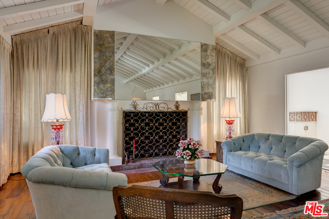 1003 Benedict Canyon Drive Beverly Hills, CA 90210 - Photo 7 of 35 a living room with furniture a couch and a window