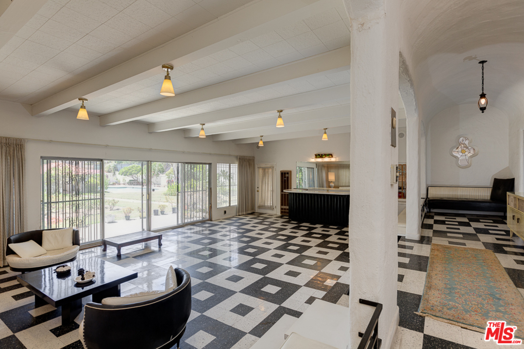 1003 Benedict Canyon Drive Beverly Hills, CA 90210 - Photo 9 of 35 a living room with furniture and a flat screen tv